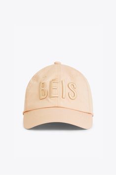 a beige baseball cap with the word bes embroidered on it's front and side