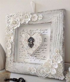 a white frame with an ornate heart and flowers on the front is sitting next to a pair of scissors