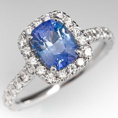 This stunning sapphire engagement ring is centered with one (1) cushion cut no heat sapphire weighing 1.60 carats and set into a four-prong head. The sapphire is bordered with sixteen (16), prong set, round brilliant cut diamonds. The top face of the shank is accented with a row of nine (9), prong set, round brilliant cut diamonds on each side. The ring measures 10.3mm at the top, rises 7.3mm above the finger, tapering to 1.9mm wide and 1.4mm thick at the base of the shank. This ring is currentl Gia Certified Cushion Cut Sapphire Ring, Formal Cushion Cut Sapphire Halo Ring, Formal Sapphire Halo Ring Cushion Cut, Formal Sapphire Cushion Cut Halo Ring, Sapphire Engagement Ring, No Heat, Shiny Things, I Love Jewelry, Sapphire Engagement