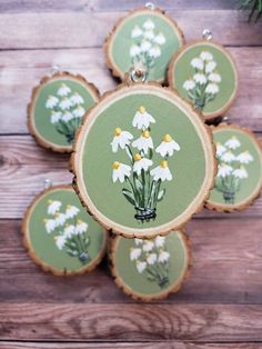 some white flowers are painted on wood slices