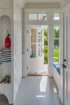 an entryway with white walls and doors leading to the front door is pictured in this image