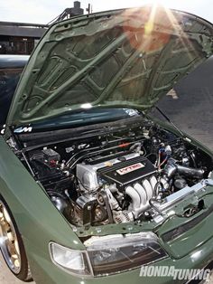 the engine compartment of a green car with its hood open