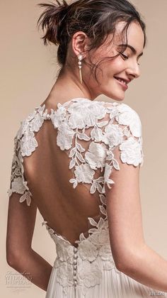 the back of a woman's wedding dress with flowers on it