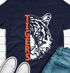 a tiger t - shirt with the word tigers on it next to jeans and sneakers