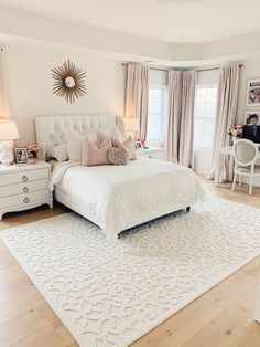 a bedroom with a white bed, desk and chair in it's center area