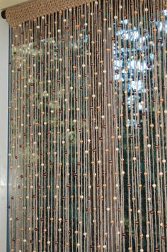 a curtain made out of beads hanging from the side of a window