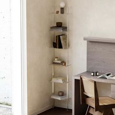 a room with a desk, chair and shelves on the wall next to each other