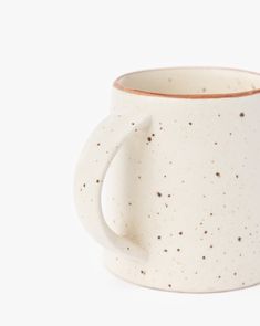 a white mug with brown speckles on it