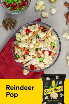 a bowl filled with popcorn and candy next to a bag of smart food white cheddar