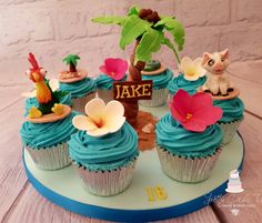 cupcakes with blue frosting and decorations on top are arranged in the shape of a tree