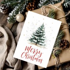 a christmas card sitting on top of a table next to pine cones and other decorations