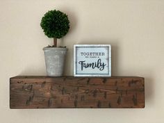 a potted plant sitting on top of a wooden shelf next to a family sign