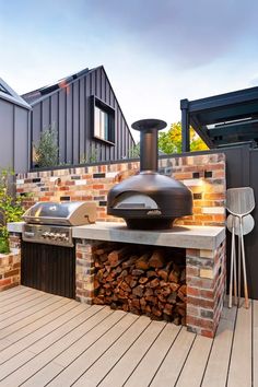 an outdoor bbq with firewood stacked on it and grilling area in the background