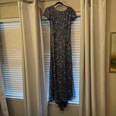 a dress hanging on a hanger in front of a window