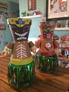 two paper mache figures sitting on top of a wooden table