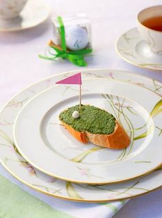 there is a small piece of bread on the plate with a flag sticking out of it