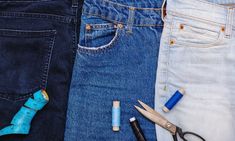 several pairs of jeans with scissors, pens and glue sitting on top of each other