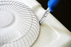 a close up of a fan on a table with a pair of blue gloves next to it