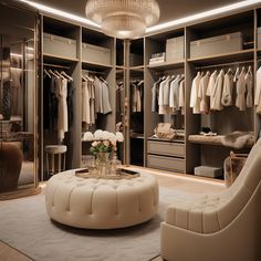 a large walk in closet with lots of clothes on hangers and a round ottoman