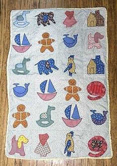 a quilted wall hanging on the floor with various animals and boats in blue, red,