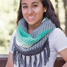 a smiling woman wearing a gray and green scarf