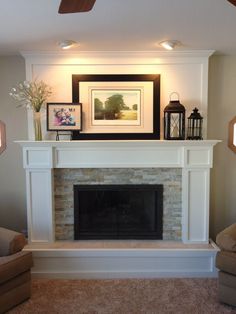 a living room with a fire place and pictures on the fireplace mantel above it