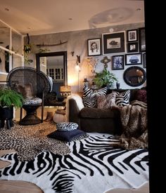 a living room with zebra print rugs and pictures on the wall behind the couch