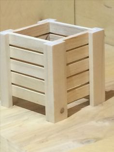 a wooden crate sitting on top of a wooden table next to a wall and floor