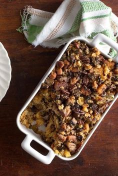 a casserole dish with nuts and other toppings next to a white plate