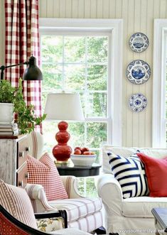 a living room filled with furniture and pillows on top of a white couch next to a window