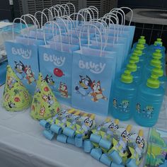 there are many bags on the table with items for sale in front of them, including water bottles