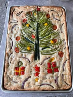 a christmas tree made out of food on top of a baking pan with utensils