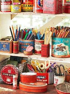 an assortment of tins and pencils on a shelf