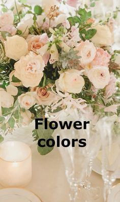 a vase filled with flowers sitting on top of a table next to candles and plates