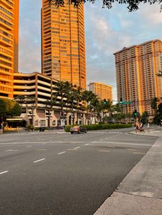 an empty street with tall buildings in the background