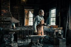 a man standing in an old fashioned blacksmith