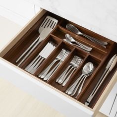 an open drawer with silverware in it