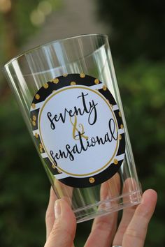 a person holding up a glass with the words seventy and inspirational on it