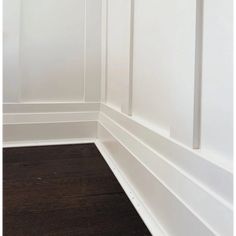 the corner of a room with white walls and wood flooring is painted dark brown