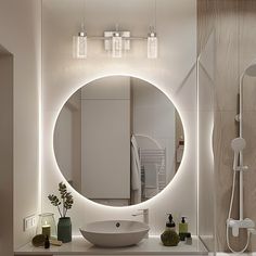 a bathroom with a round mirror above the sink and lights on the wall behind it