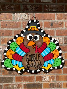 a turkey shaped sign on the side of a brick building that says gobble baby