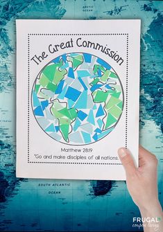 a person holding up a book with the words, the great commission on it in front of a world map