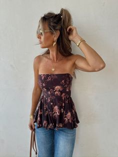 Embrace timeless elegance with the Rosy Outlook Top from Copper and Cloth! This strapless brown floral peplum top features a flattering smocked back with a zipper for the perfect fit. Whether you're dressing it up for a special occasion or keeping it casual, this top adds a touch of romance to any look. Grab yours now! Chic Peplum Top With Smocked Back For Brunch, Peplum Top With Ruffle Hem For Day Out, Fitted Tops With Smocked Back For Date Night, Casual Bandeau Top For Date Night, Spring Season Smocked Back Top For Date Night, Spring Night Out Tops With Smocked Back, Spring Night Out Top With Smocked Back, Chic Smocked Bodice Top For Date Night, Strapless Ruffled Tops For Day Out