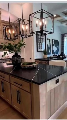 a kitchen with an island and chandelier hanging from it's center beam