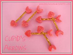 four pink hearts are attached to the branches of a tree with gold colored stems and leaves