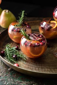 three glasses filled with fruit and garnish on a plate