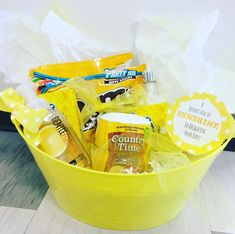 a yellow bucket filled with snacks and condiments