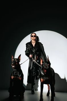 a woman walking two dogs on a leash