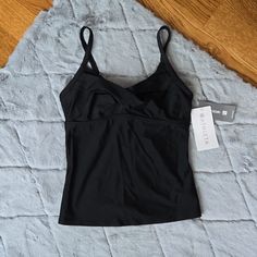 This Black Twister Tankini Made By Athleta Is New With Tags! Perfect If You Prefer Some Extra Coverage While Swimming At The Beach Or Pool This Summer. Does Not Have The Removable Pads In The Bust, They Are Missing. Women's Size 34 B/C. Flat Lay Measurements Approximately 14 Inches Pit To Pit And 14.5 Inches In Length. The Shoulder Straps Are Adjustable. Please See Photos For Additional Measurements, Make Of Fabric And Care Instructions. Measurements Are Approximate, Please See Photos. Color Is Fitted Black Sports Tankini, Black Seamless Tankini For Workout, Black Seamless Sports Tankini, Fitted Moisture-wicking Tankini For Workout, Sporty Fitted Tankini For Gym, Black Stretch Athleisure Tankini, Black Athleisure Stretch Tankini, Black Fitted Sporty Tankini, Sporty Fitted Black Tankini