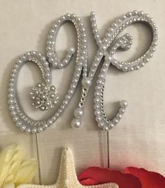 there is a cake topper with the letter e on it and some flowers next to it